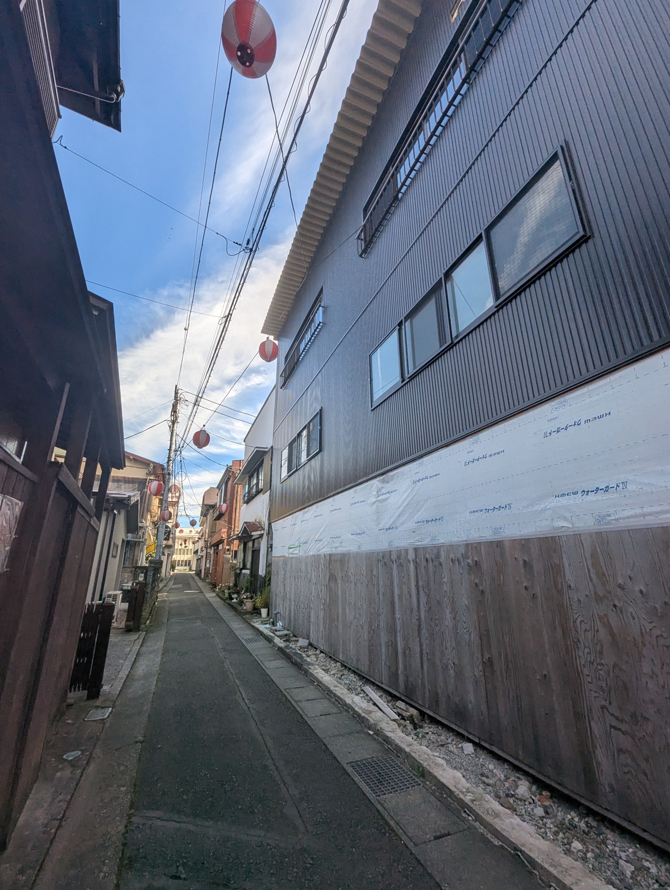 Existing Shimoyoshida lane-side exterior with unfinished ground-level facade